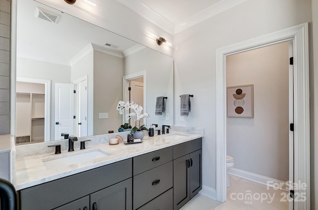 bathroom featuring crown molding, vanity, tile patterned floors, and toilet