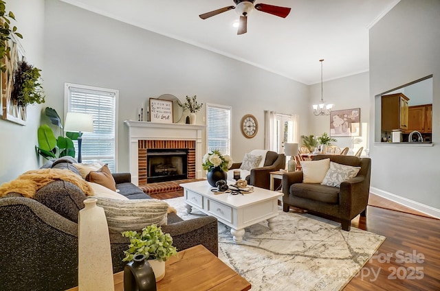 living room featuring a wealth of natural light, wood-type flooring, ornamental molding, and a towering ceiling