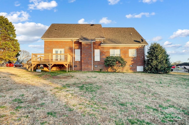 back of property featuring a wooden deck and a yard