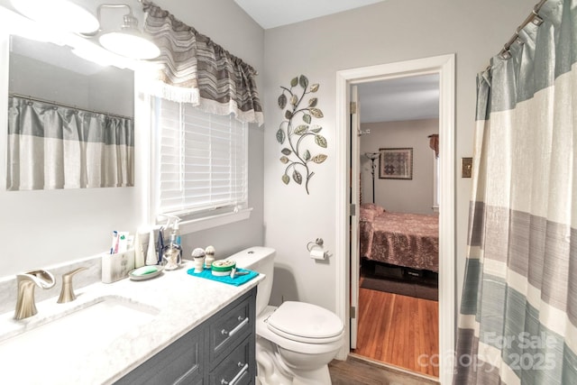 bathroom with vanity, toilet, and hardwood / wood-style floors