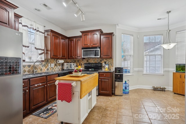 kitchen with light tile patterned floors, decorative backsplash, appliances with stainless steel finishes, and visible vents