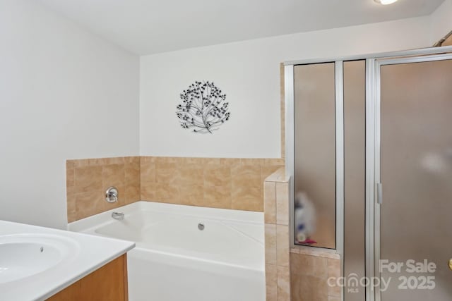 bathroom with a shower stall, vanity, and a garden tub