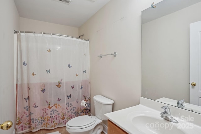 bathroom featuring visible vents, toilet, vanity, and a shower with shower curtain