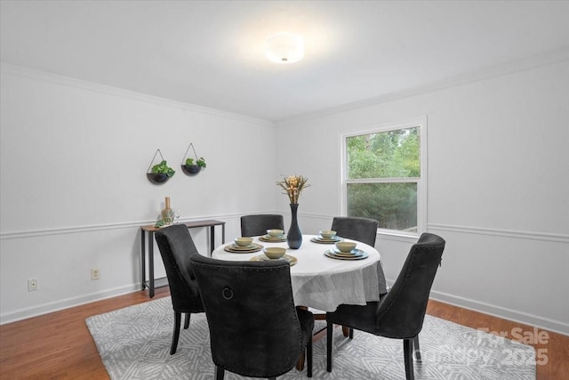 dining area featuring hardwood / wood-style floors and crown molding