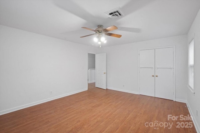 unfurnished bedroom featuring ceiling fan, a closet, and light hardwood / wood-style flooring