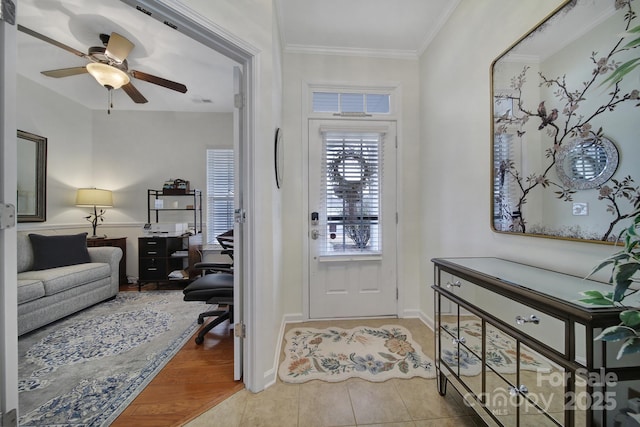 tiled entryway with ceiling fan and ornamental molding