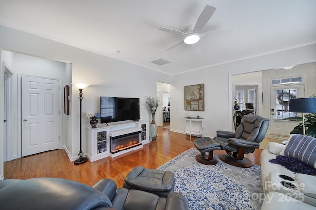 living room with ceiling fan, hardwood / wood-style floors, and crown molding