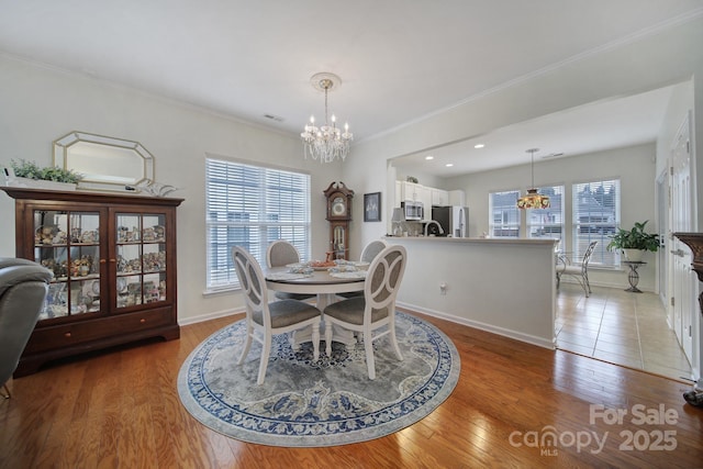 dining space with light hardwood / wood-style floors, a chandelier, and plenty of natural light