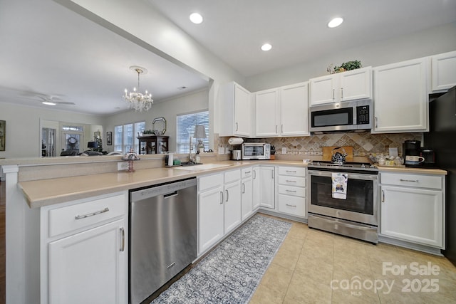 kitchen featuring white cabinetry, kitchen peninsula, and appliances with stainless steel finishes