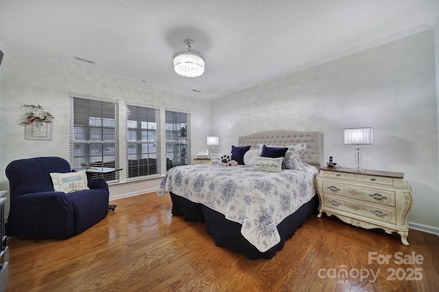 bedroom with ornamental molding and hardwood / wood-style floors