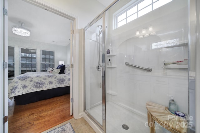 bathroom featuring tile patterned flooring, a notable chandelier, and a shower with shower door