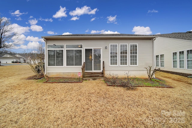 rear view of house featuring a yard