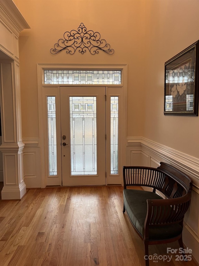 entrance foyer featuring decorative columns and light hardwood / wood-style flooring