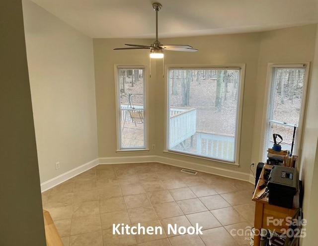 unfurnished dining area with light tile patterned floors, a wealth of natural light, and ceiling fan