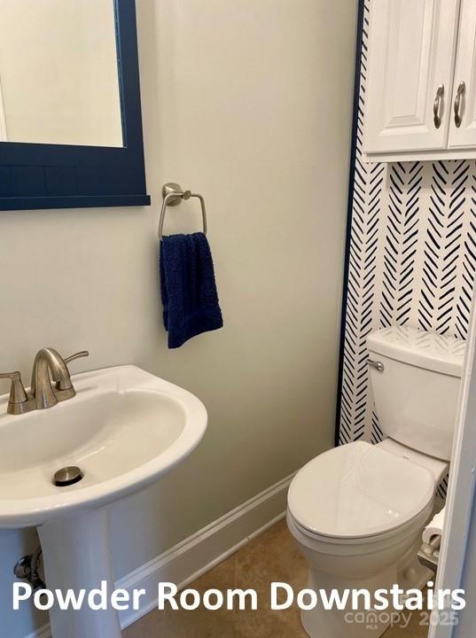 bathroom featuring tile patterned flooring, toilet, and sink