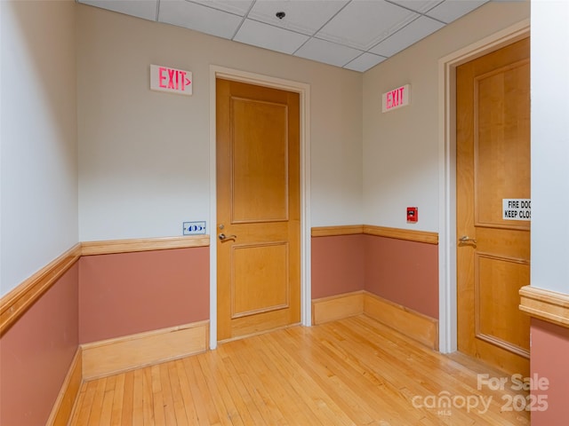 unfurnished room featuring hardwood / wood-style flooring and a paneled ceiling