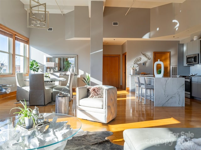 living room featuring light hardwood / wood-style floors and a high ceiling