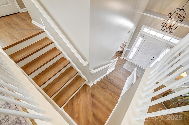 foyer entrance featuring hardwood / wood-style flooring, a high ceiling, and an inviting chandelier