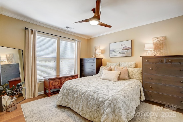 bedroom with ceiling fan, crown molding, and light wood-type flooring