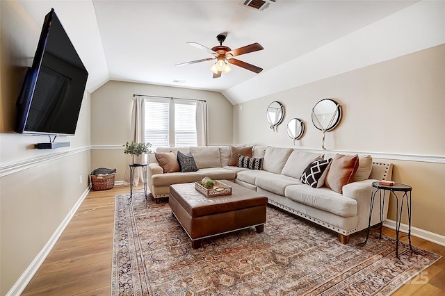 living room with hardwood / wood-style flooring, vaulted ceiling, and ceiling fan