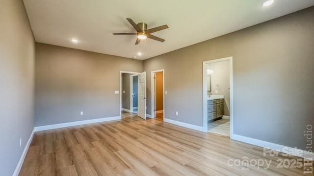 unfurnished bedroom with ceiling fan, light wood-type flooring, and connected bathroom