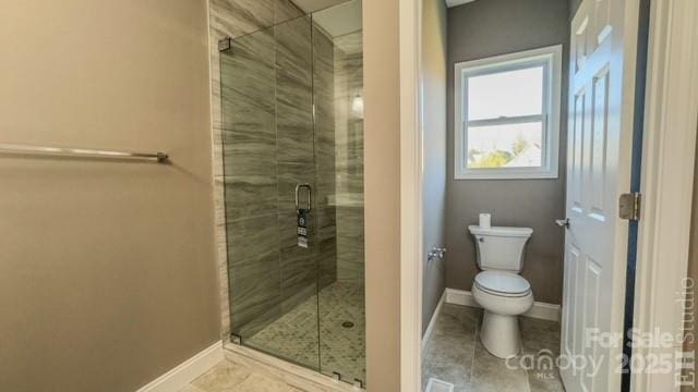 bathroom featuring tile patterned floors, toilet, and a shower with door