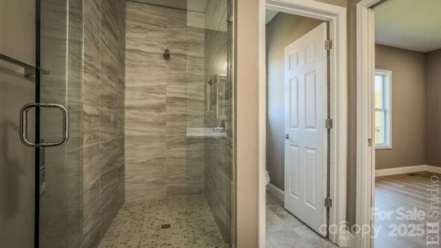 bathroom featuring an enclosed shower and toilet