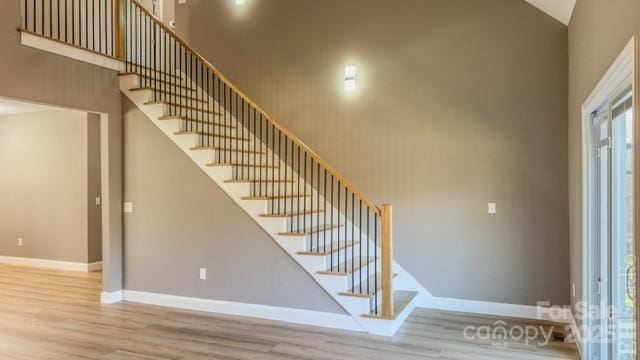 stairs with a high ceiling and hardwood / wood-style flooring