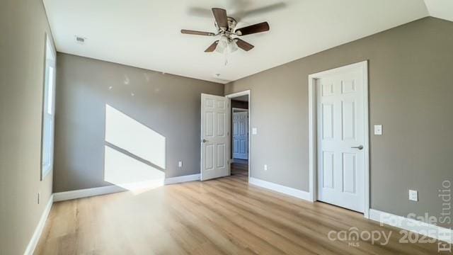 unfurnished bedroom featuring ceiling fan, lofted ceiling, and light wood-type flooring