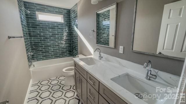 full bathroom featuring tiled shower / bath, vanity, and toilet