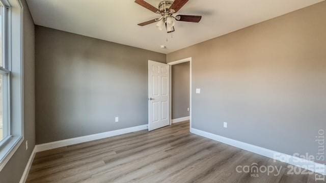 empty room with ceiling fan and light wood-type flooring