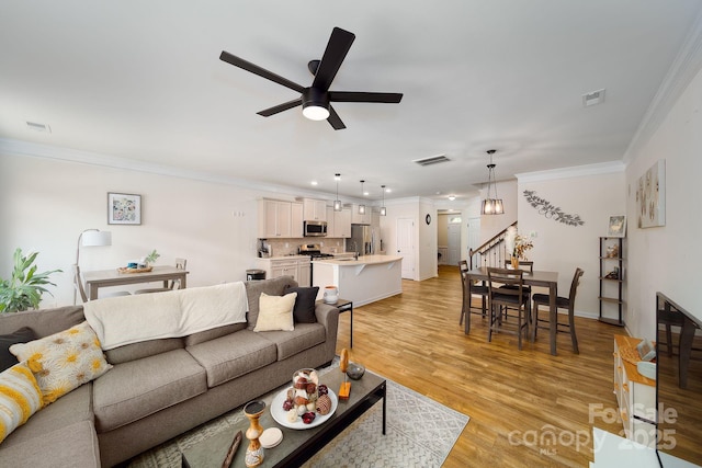 living room featuring ceiling fan, light wood-type flooring, and ornamental molding