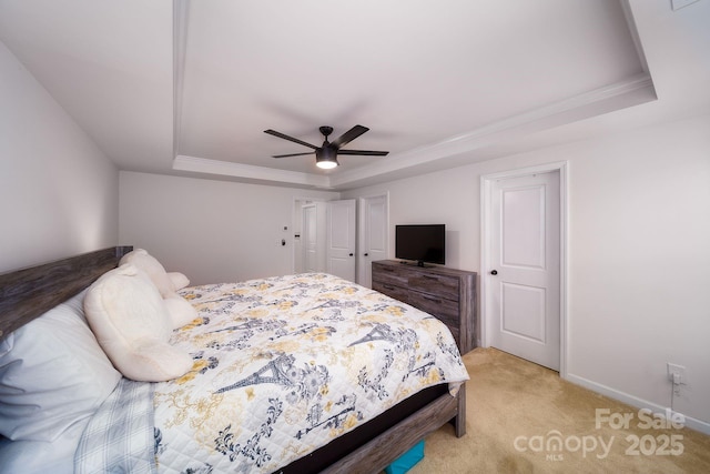 bedroom featuring light colored carpet, a raised ceiling, ceiling fan, and crown molding