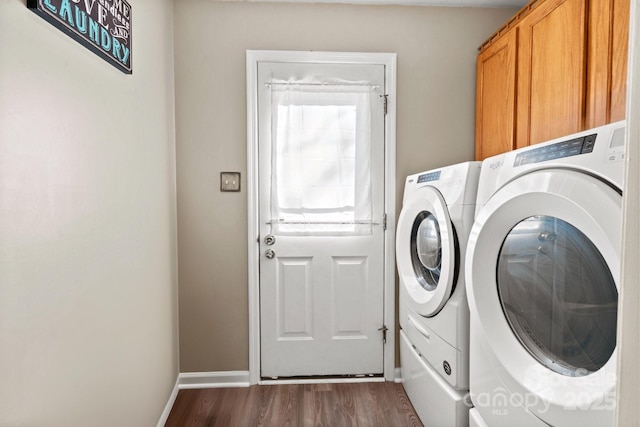 laundry area featuring cabinets, washer and dryer, and dark hardwood / wood-style floors