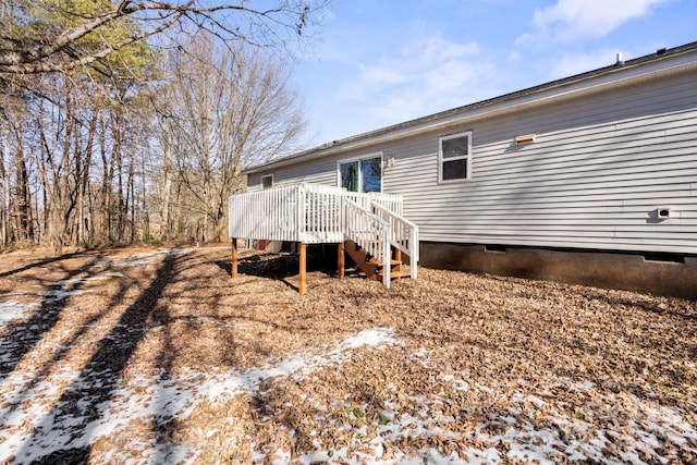 snow covered house featuring a deck