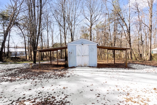 snow covered structure with a carport