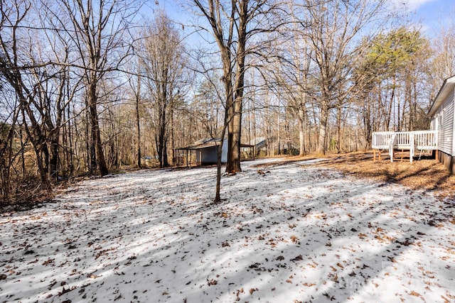 snowy yard featuring a wooden deck