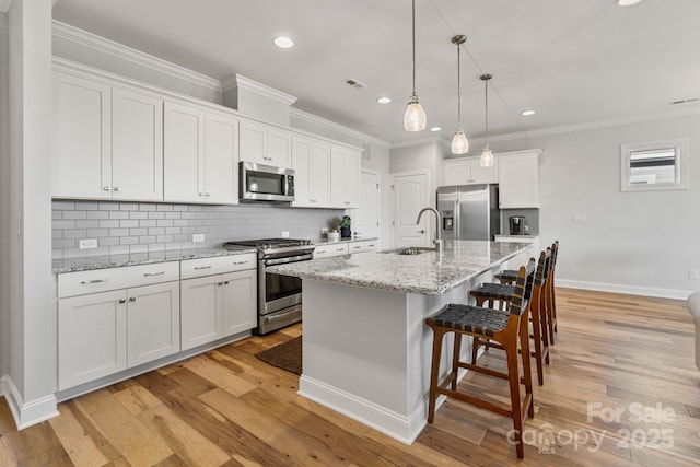 kitchen with white cabinetry, sink, an island with sink, and appliances with stainless steel finishes