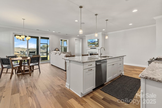 kitchen featuring white cabinetry, dishwasher, sink, hanging light fixtures, and light stone counters