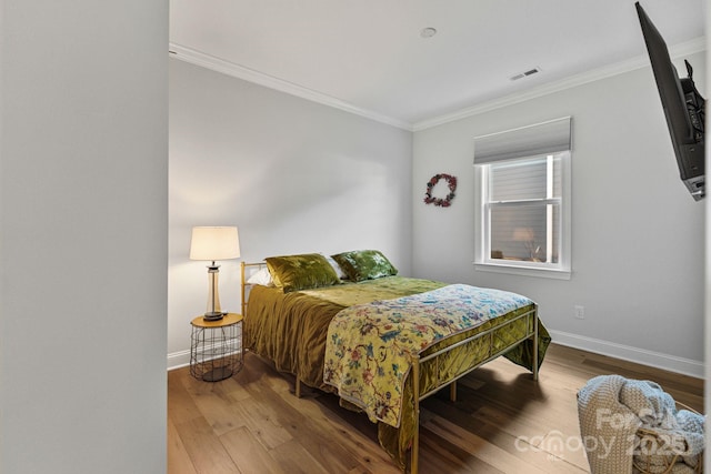 bedroom with hardwood / wood-style flooring and ornamental molding