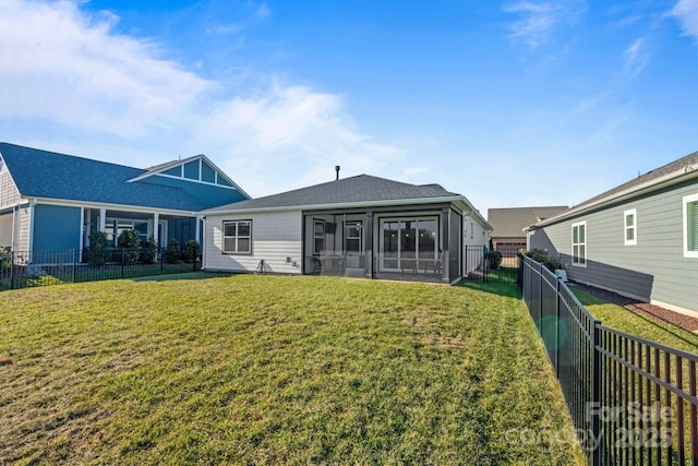 back of property with a lawn and a sunroom