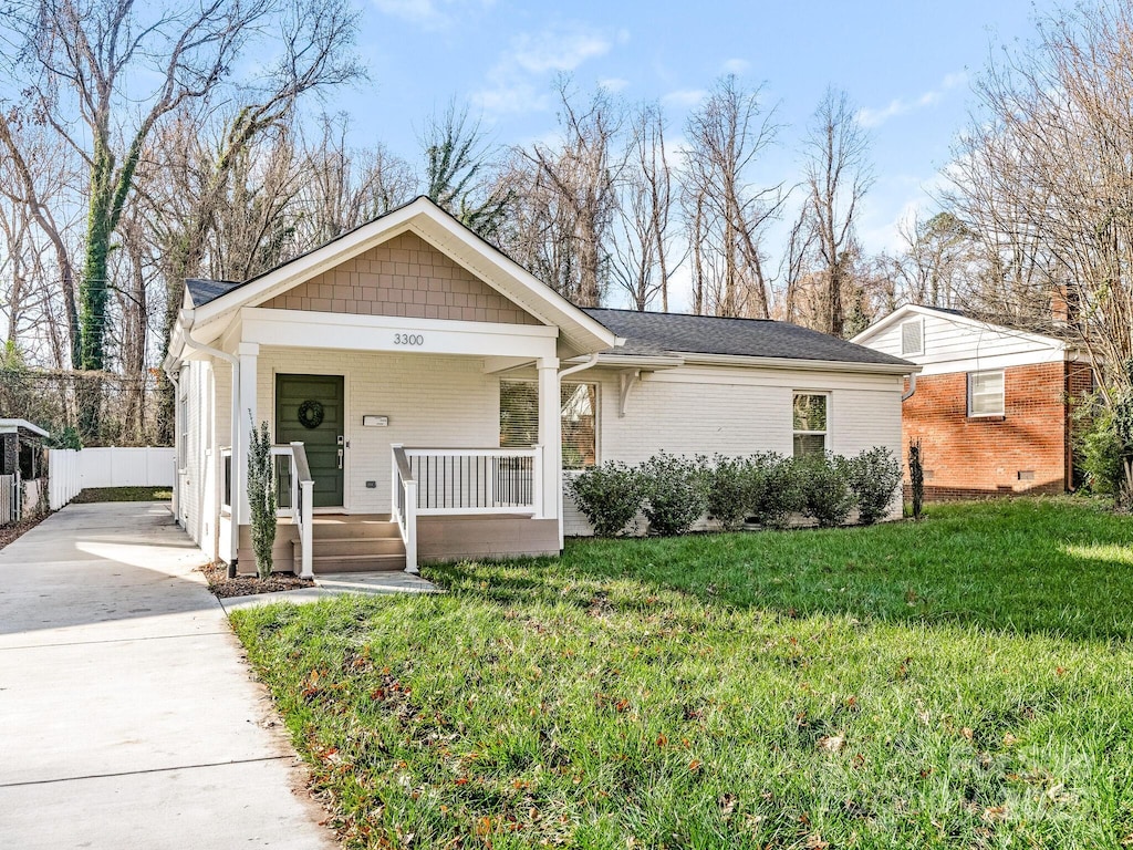 ranch-style home with a porch and a front lawn