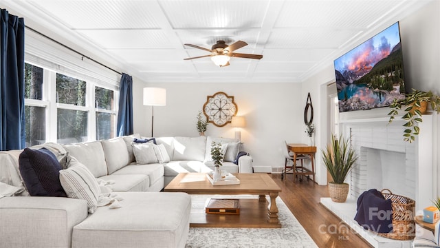 living room featuring a fireplace, hardwood / wood-style floors, ceiling fan, and coffered ceiling