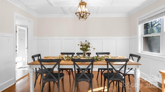 dining area with a chandelier, wood-type flooring, and coffered ceiling