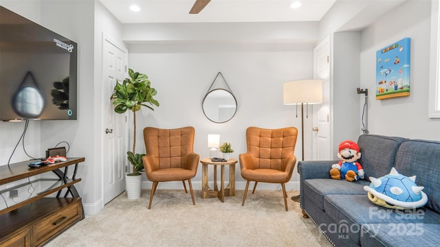 living area with ceiling fan and light carpet