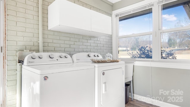 laundry room featuring washer and dryer, dark hardwood / wood-style flooring, and cabinets