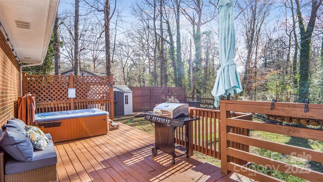 wooden terrace featuring a storage shed, grilling area, and a hot tub