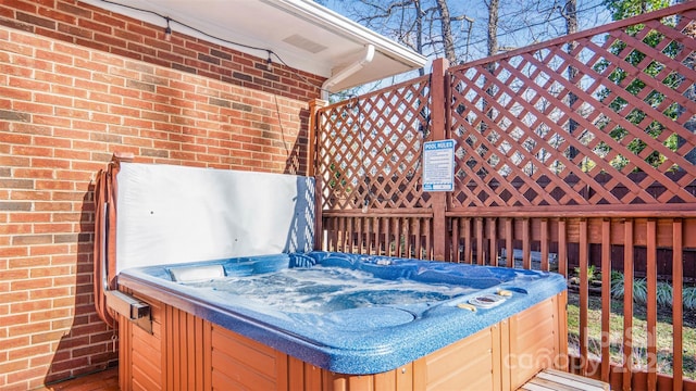 wooden terrace featuring a hot tub