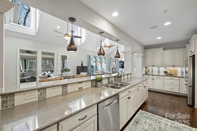 kitchen with light stone countertops, appliances with stainless steel finishes, white cabinets, and sink