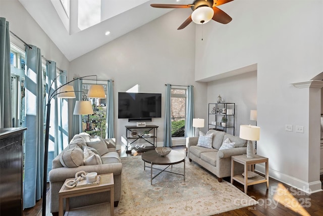 living room featuring hardwood / wood-style floors, a towering ceiling, and ceiling fan